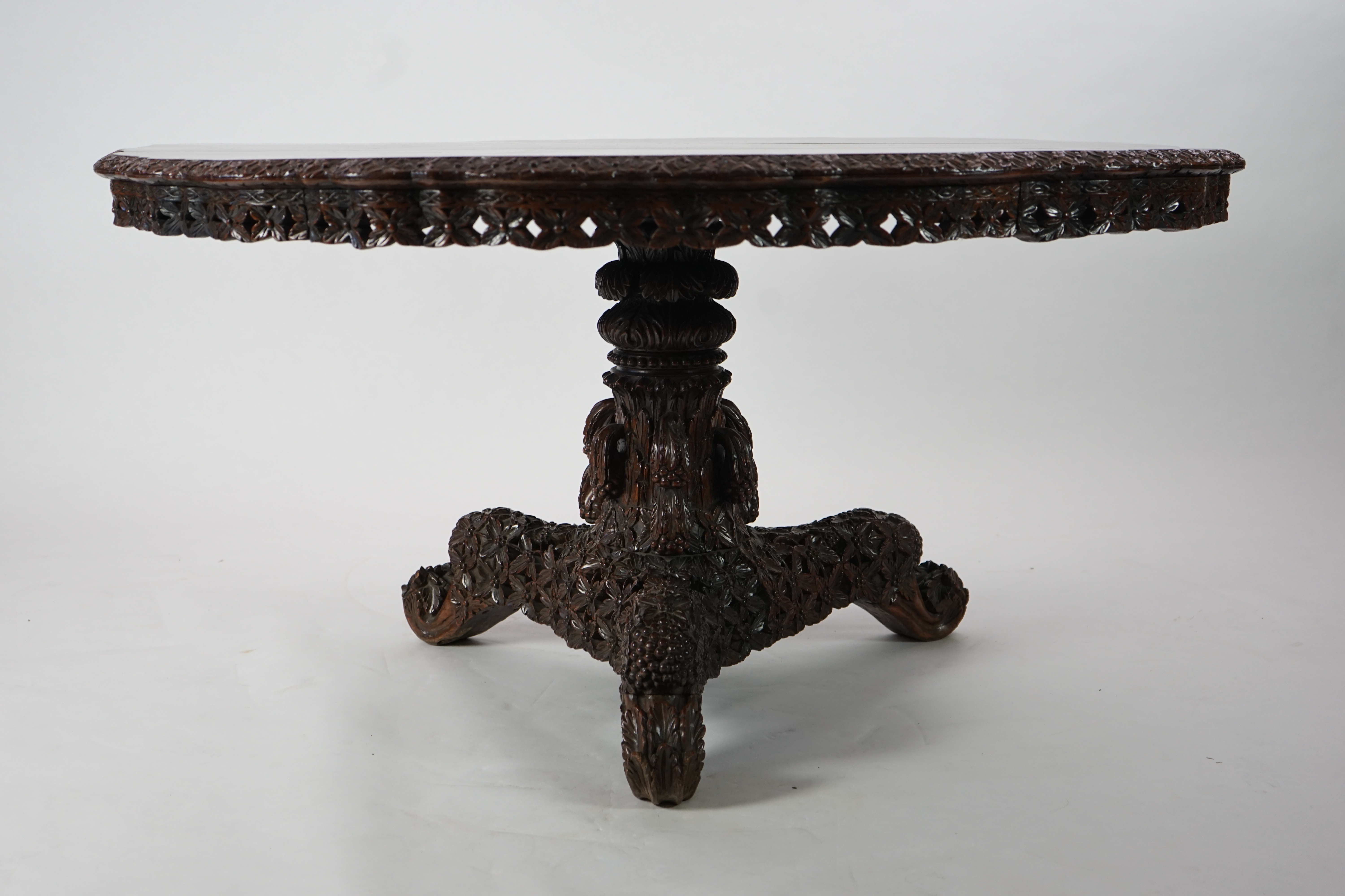 A 19th century Anglo-Indian hardwood foliate carved tilt top centre table